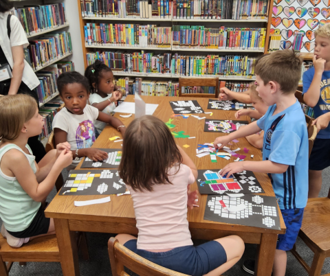 A group of children around a table doing crafts