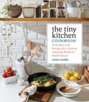 Cover of a cookbook showing a kitchen counter with a fryin pan and bowl of food, and and shelf with various spices and ingredients