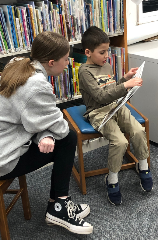 a child reading to a teen