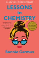 A salmon colored book with the face of a woman wearing sunglasses and the title Lessons in Chemistry.